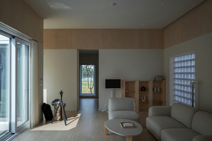 Interior rumah modern yang fleksibel dengan ruang keluarga dan pintu kaca
